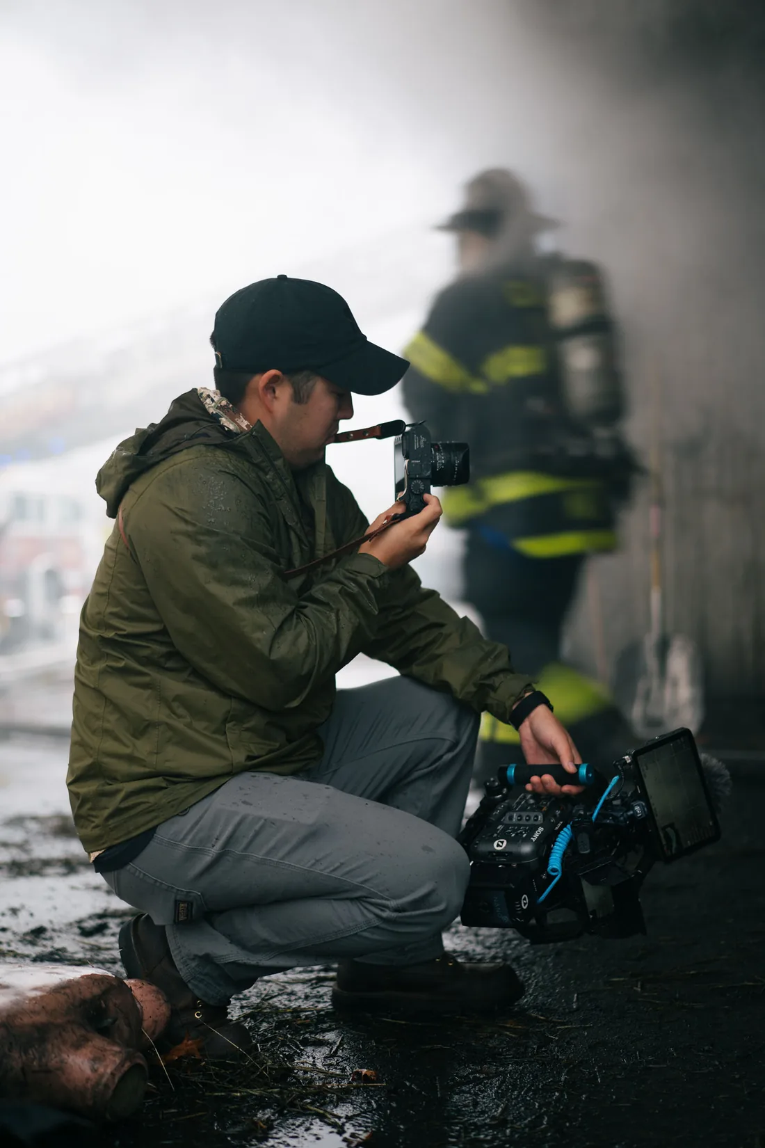 Signal operator documenting a live fire scene in smoke